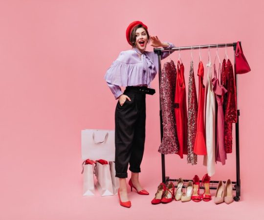 spectacular-lady-black-pants-coquettishly-lifts-her-leg-holds-bag-pink-background-with-packages-after-shopping_197531-17601